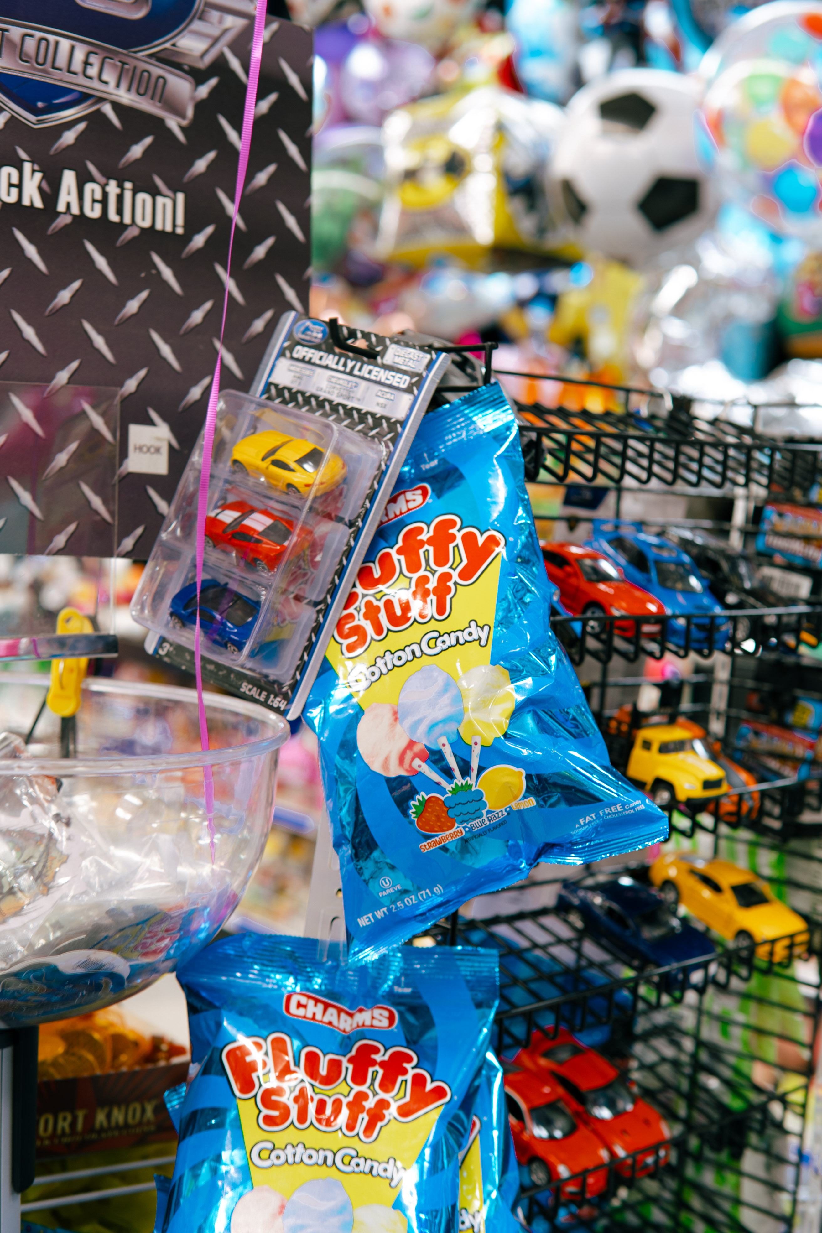Fluffy Stuff cotton candy and diecast toy cars on wire rack